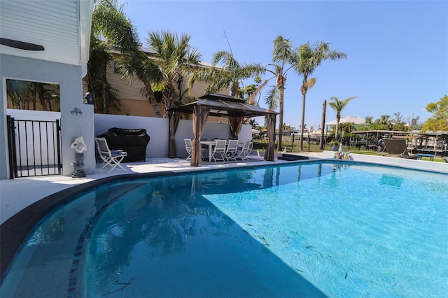 view of pool with a gazebo, a patio, fence, and a fenced in pool