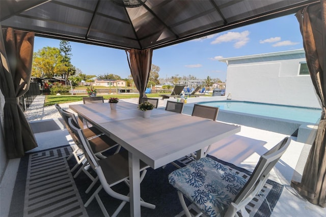 view of patio with a gazebo, outdoor dining space, and an outdoor pool