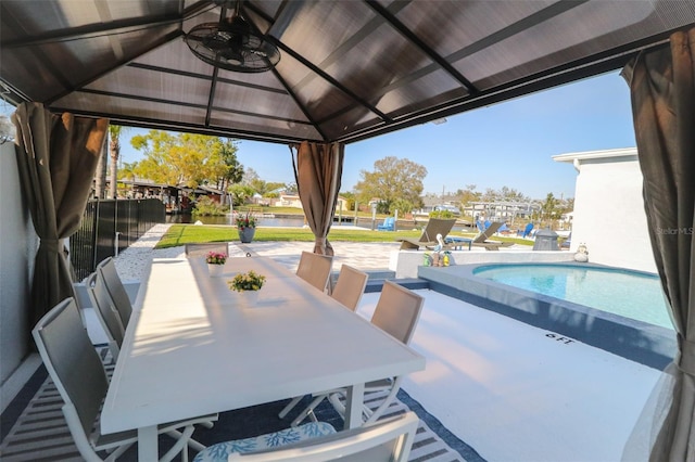 view of patio / terrace with a gazebo, an outdoor pool, outdoor dining space, and ceiling fan