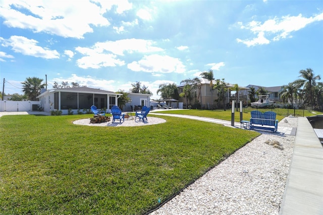 view of yard with a patio, a gate, fence, an outdoor fire pit, and a sunroom