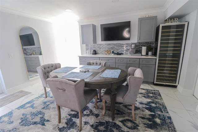 dining area with baseboards, beverage cooler, marble finish floor, and ornamental molding