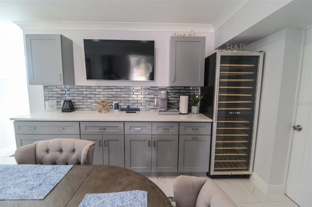 bar featuring decorative backsplash, marble finish floor, beverage cooler, and ornamental molding