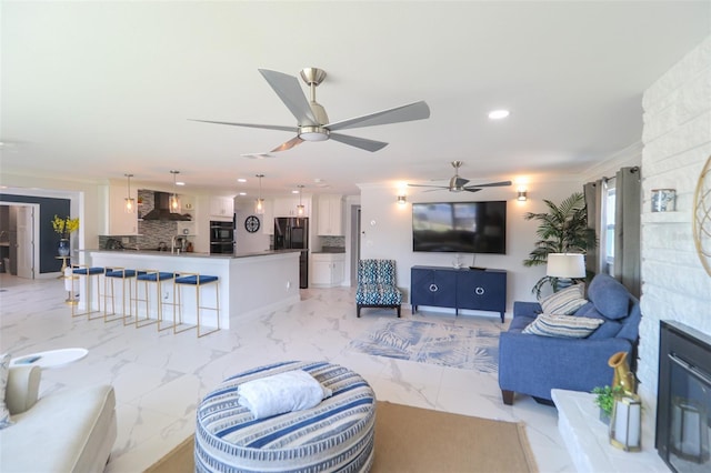 living area featuring a ceiling fan, recessed lighting, and marble finish floor