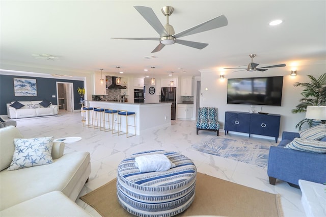 living area with recessed lighting, marble finish floor, and ceiling fan