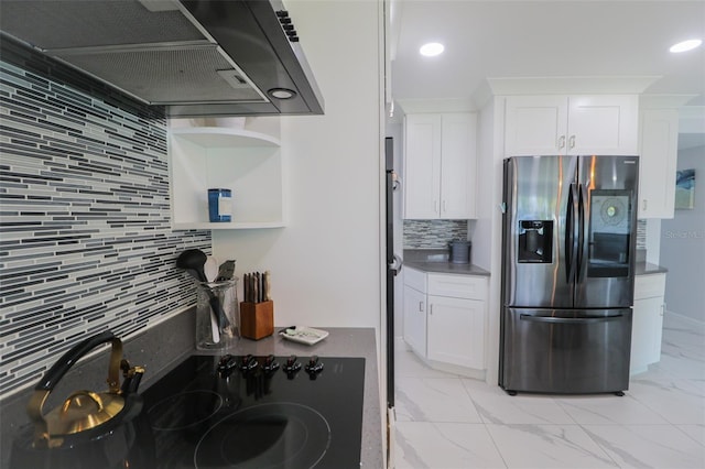 kitchen with backsplash, range hood, white cabinets, stainless steel fridge, and marble finish floor