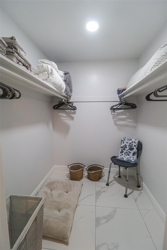 spacious closet featuring marble finish floor