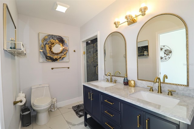 bathroom featuring a sink, toilet, marble finish floor, and double vanity