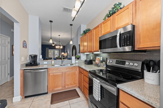 kitchen featuring light tile patterned floors, visible vents, a sink, stainless steel appliances, and backsplash