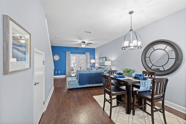 dining space with a ceiling fan, visible vents, wood finished floors, and baseboards