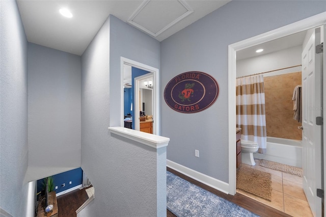 hall featuring recessed lighting, baseboards, attic access, and tile patterned flooring