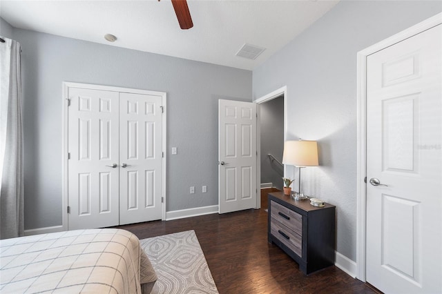 bedroom featuring dark wood-style floors, visible vents, baseboards, ceiling fan, and a closet