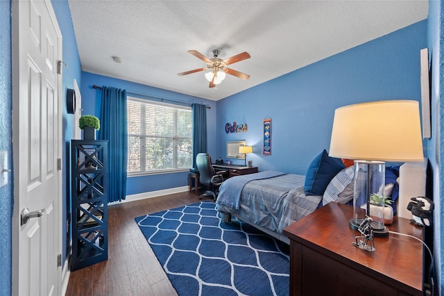 bedroom featuring a textured ceiling, a ceiling fan, baseboards, and wood finished floors