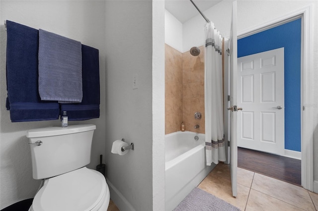 bathroom featuring tile patterned flooring, shower / bath combination with curtain, toilet, and baseboards