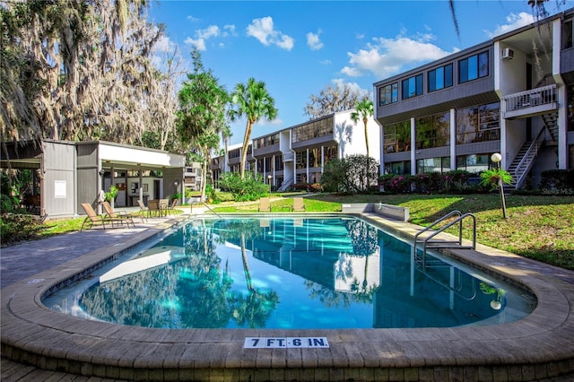 community pool featuring a residential view, a patio, and a yard