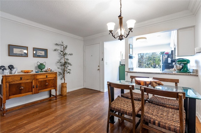 dining area featuring baseboards, an inviting chandelier, wood finished floors, and crown molding