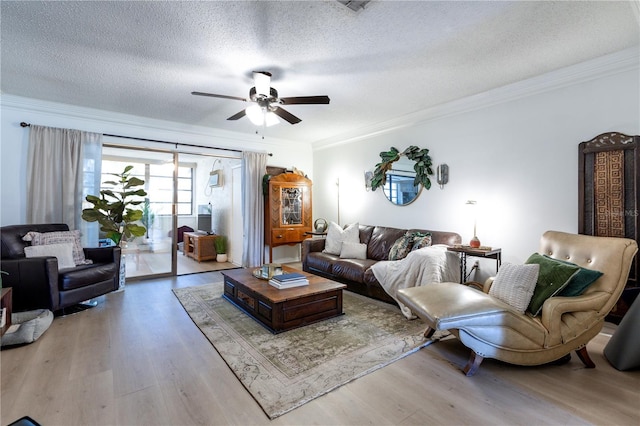 living room with a textured ceiling, ornamental molding, wood finished floors, and ceiling fan