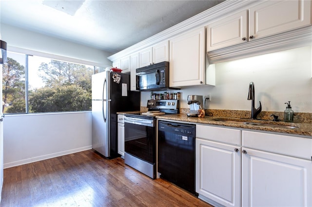 kitchen with baseboards, dark wood-style flooring, a sink, black appliances, and white cabinets