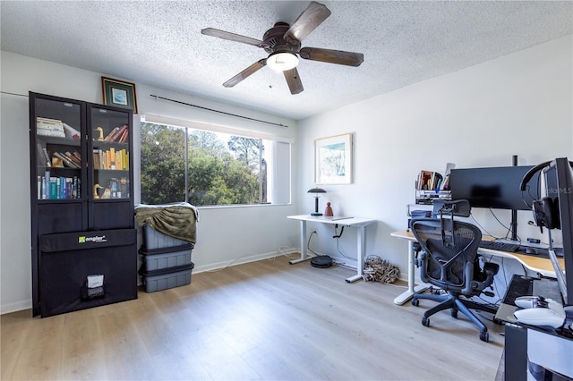 office with ceiling fan, baseboards, a textured ceiling, and wood finished floors