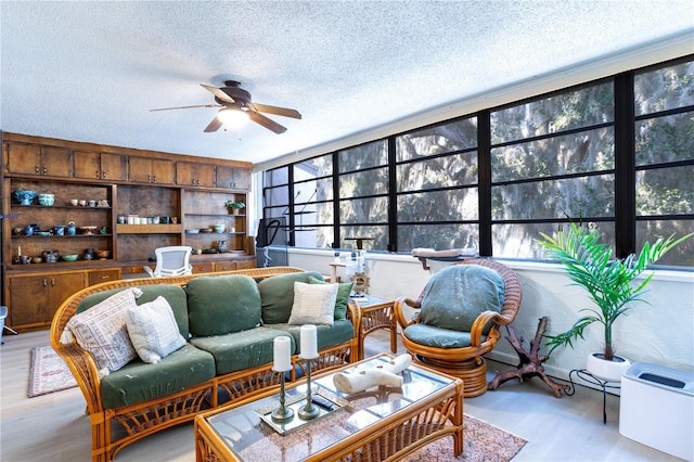 living area with light wood finished floors, a textured ceiling, and ceiling fan