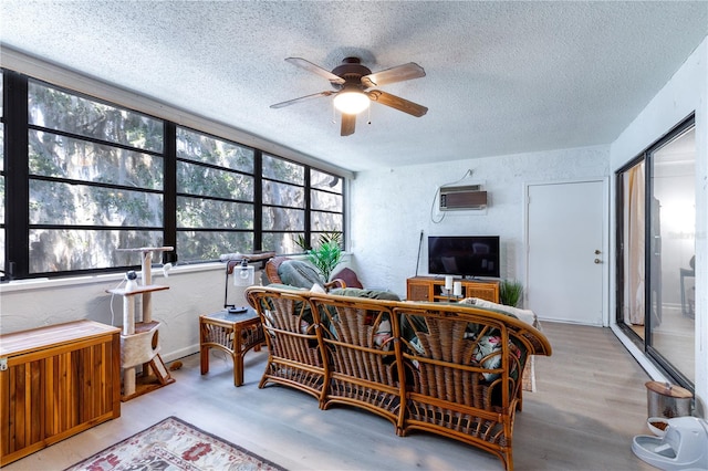 interior space featuring an AC wall unit and a ceiling fan