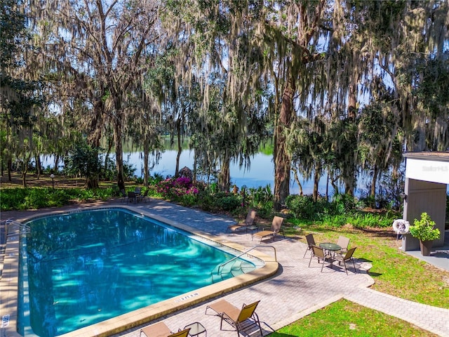 outdoor pool with a patio and a water view