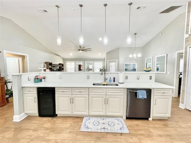 kitchen featuring a sink, light countertops, lofted ceiling, and stainless steel dishwasher