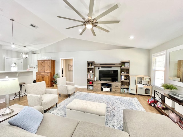 living area with a ceiling fan, visible vents, baseboards, vaulted ceiling, and light wood-style floors