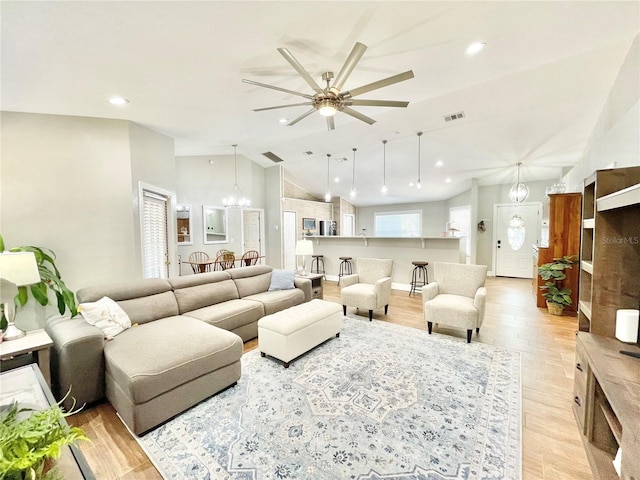 living area with visible vents, light wood-style flooring, recessed lighting, vaulted ceiling, and ceiling fan with notable chandelier