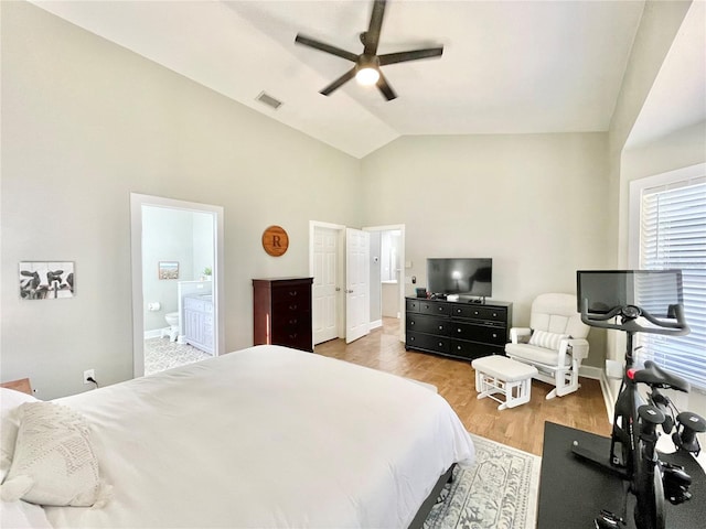 bedroom with baseboards, visible vents, lofted ceiling, light wood-style flooring, and ensuite bathroom