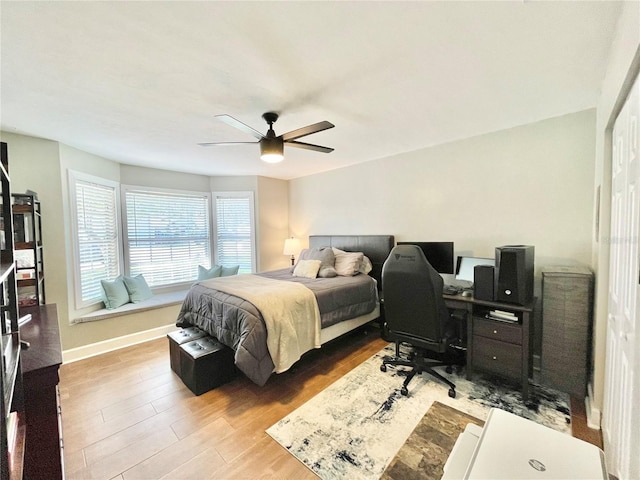 bedroom with baseboards, a ceiling fan, and wood finished floors