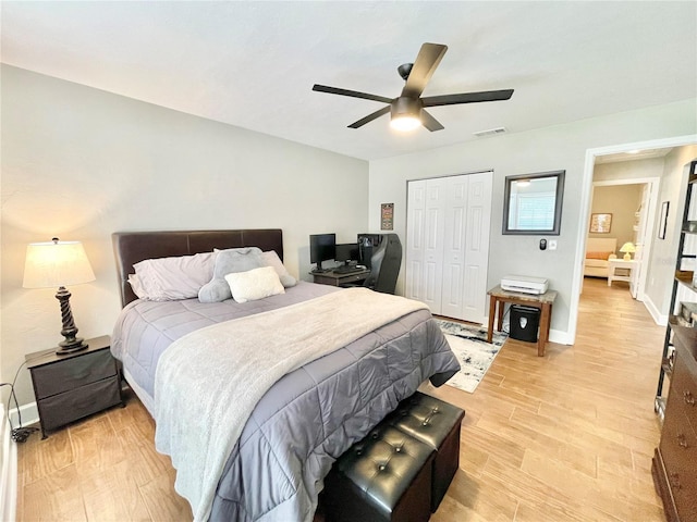 bedroom with a ceiling fan, baseboards, visible vents, a closet, and light wood-type flooring