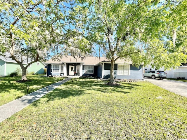 ranch-style house featuring driveway and a front yard