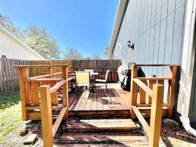 wooden terrace featuring outdoor dining area and a fenced backyard