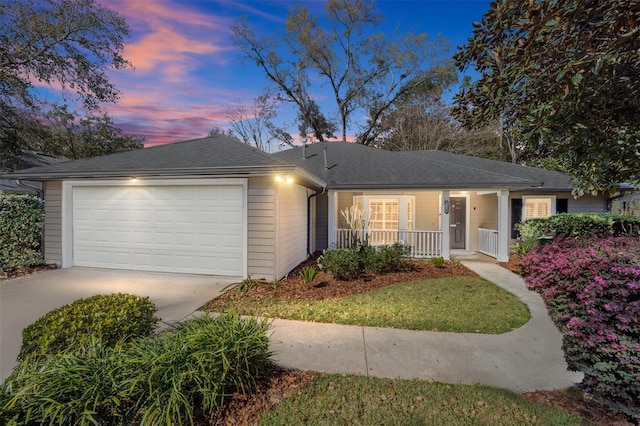 ranch-style house featuring roof with shingles, a porch, concrete driveway, and an attached garage