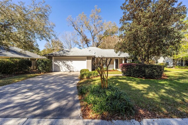 view of front facade with a front yard, concrete driveway, and an attached garage