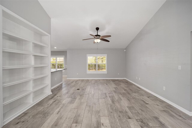 unfurnished living room featuring light wood-style flooring, a ceiling fan, and baseboards