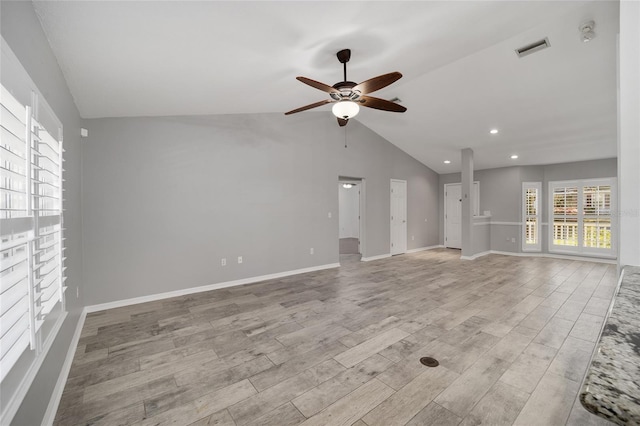 unfurnished living room with baseboards, visible vents, ceiling fan, vaulted ceiling, and light wood-style floors