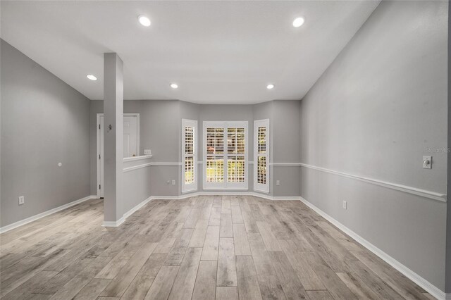 empty room with recessed lighting, baseboards, and light wood finished floors