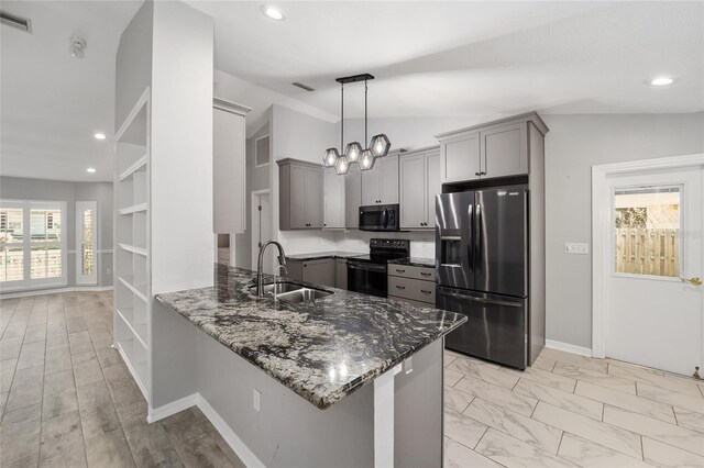 kitchen featuring a sink, dark stone counters, gray cabinets, and stainless steel appliances