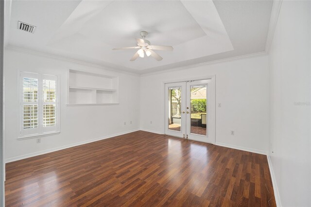 unfurnished room featuring visible vents, built in features, wood finished floors, and baseboards