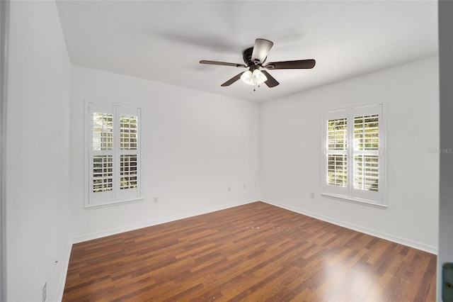 spare room with a healthy amount of sunlight, baseboards, and wood finished floors