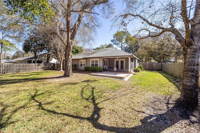 back of house featuring french doors, a lawn, a fenced backyard, and a patio area