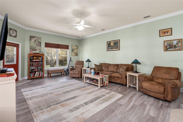 living area featuring visible vents, wood finished floors, and ornamental molding