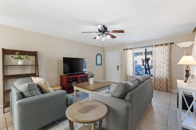 living area with light tile patterned flooring, baseboards, and ceiling fan