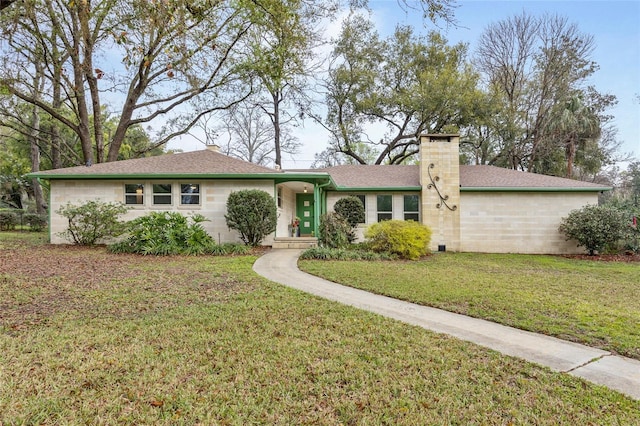 ranch-style home featuring a chimney, a front lawn, and roof with shingles