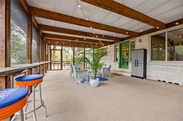 unfurnished sunroom with beamed ceiling