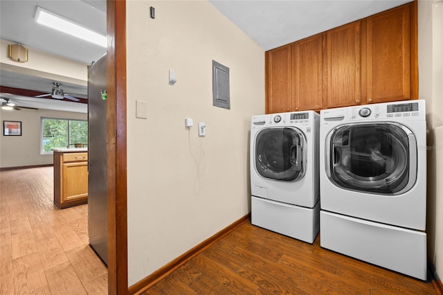 laundry room with washing machine and clothes dryer, cabinet space, baseboards, and light wood-style floors