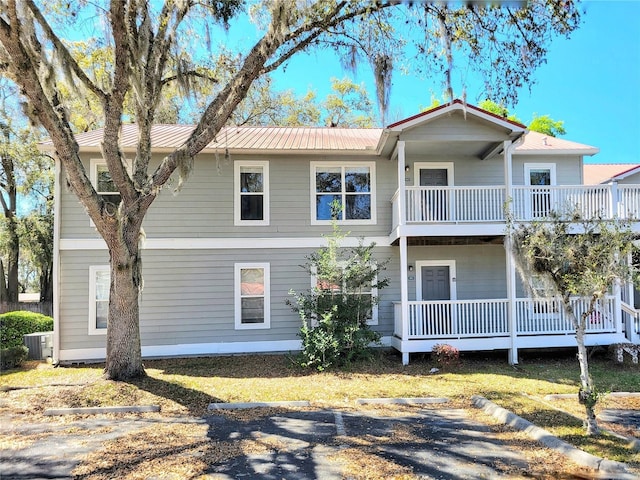 view of front of house featuring a balcony, central AC unit, covered porch, and metal roof