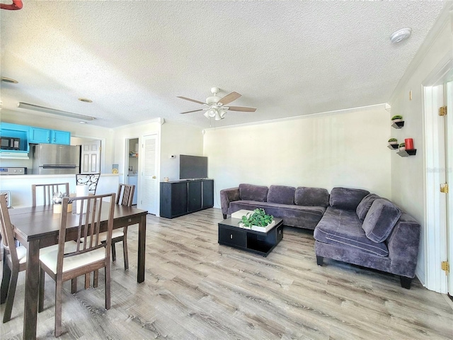 living area featuring crown molding, a ceiling fan, light wood-type flooring, and a textured ceiling