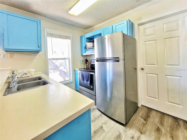 kitchen with ornamental molding, blue cabinetry, a sink, light wood-style floors, and appliances with stainless steel finishes